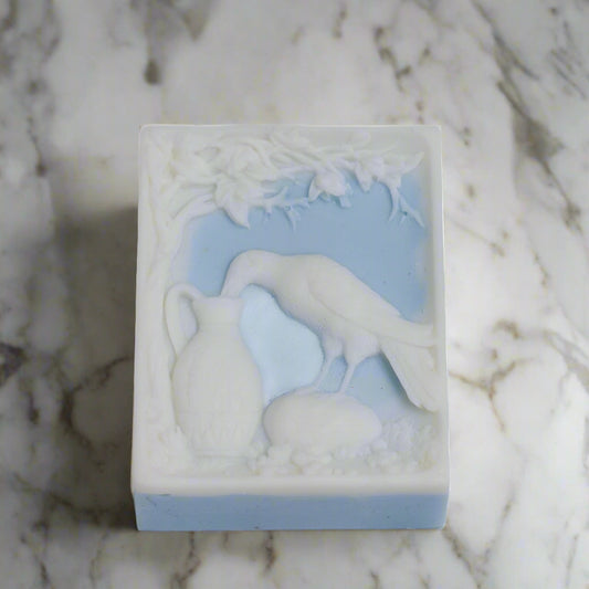 Bar of soap with a design of a bird and landscape on a white background